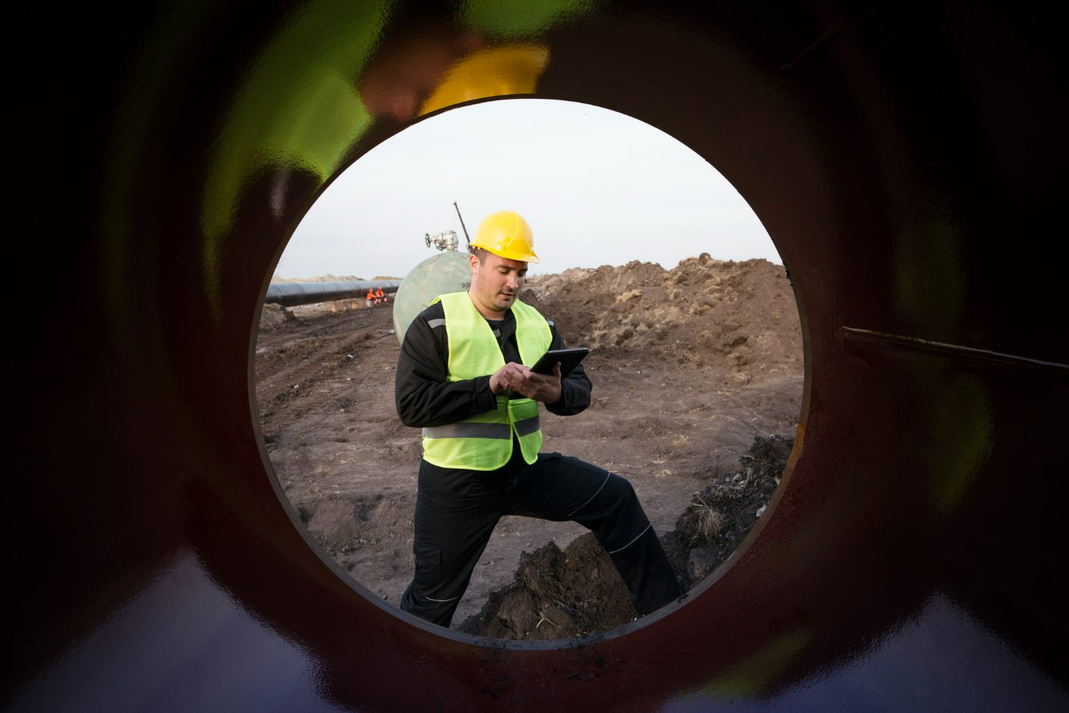 shot-oilfield-worker-checking-quality-gas-pipes-construction-site shot-oilfield-worker-checking-quality-gas-pipes-construction-site